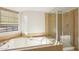 Bright bathroom features a soaking tub and a frameless glass shower with neutral tiling at 250 W Juniper Ave # 22, Gilbert, AZ 85233
