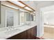 Bathroom vanity with dual sinks, dark wood cabinets, quartz countertop and a large mirror at 250 W Juniper Ave # 22, Gilbert, AZ 85233