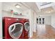 Laundry room with red washer and dryer next to an open living area at 250 W Juniper Ave # 22, Gilbert, AZ 85233