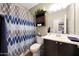 Bathroom with a vanity, patterned shower curtain, cabinet, and wood-look flooring at 30446 W Picadilly Rd, Buckeye, AZ 85396