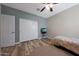 Bedroom with neutral walls, wood look flooring, fan, a TV and double closet at 30446 W Picadilly Rd, Buckeye, AZ 85396