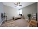 Bedroom with neutral walls, wood look flooring, fan, a TV and a round rug at 30446 W Picadilly Rd, Buckeye, AZ 85396