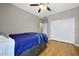 This bedroom features wood flooring, a ceiling fan, and a spacious closet with sliding doors at 30446 W Picadilly Rd, Buckeye, AZ 85396