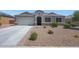 Inviting single-story home featuring an attached two-car garage, low maintenance landscaping, and a covered front entryway at 30446 W Picadilly Rd, Buckeye, AZ 85396