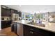 Open concept kitchen with island seating, dark wood cabinets, and stainless steel appliances at 30446 W Picadilly Rd, Buckeye, AZ 85396