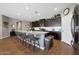 Spacious kitchen with a large island, seating, dark cabinets, and wood-look tile floors at 30446 W Picadilly Rd, Buckeye, AZ 85396