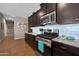 Bright, modern kitchen with stainless steel appliances, granite countertops, and dark wood cabinets at 30446 W Picadilly Rd, Buckeye, AZ 85396