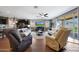 Open-concept living room featuring two sofas, a ceiling fan and sliding glass doors at 30446 W Picadilly Rd, Buckeye, AZ 85396