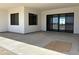 A spacious covered patio with a concrete floor, black trimmed windows and door providing natural light and outdoor living at 31060 N 213Th Dr, Wittmann, AZ 85361