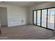 A spacious living room with modern wood look tile flooring, a custom fireplace wall, and large sliding glass doors to patio at 31060 N 213Th Dr, Wittmann, AZ 85361