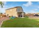 Expansive backyard features lush artificial turf, covered patio, and ample space for outdoor activities and relaxation at 38659 N Alamo Ct, San Tan Valley, AZ 85140