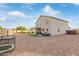 Expansive backyard with a covered patio, playground, and low-maintenance gravel landscaping and artificial grass at 38659 N Alamo Ct, San Tan Valley, AZ 85140