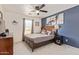 Stylish bedroom featuring a statement blue wall, wooden furniture and a bed with decorative throw pillows at 38659 N Alamo Ct, San Tan Valley, AZ 85140
