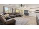 Open-concept living room boasts a sizable sectional, wood floors, and seamless access to the backyard at 38659 N Alamo Ct, San Tan Valley, AZ 85140