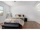 Well-lit bedroom features a ceiling fan, a window, a mirror, and a bed with a storage bench at 39959 W Williams Way, Maricopa, AZ 85138