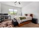 Bright bedroom featuring a ceiling fan, a large window, a desk, a chair, and a large bed at 39959 W Williams Way, Maricopa, AZ 85138
