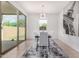 Bright dining room featuring modern light fixture and access to the outdoor patio at 39959 W Williams Way, Maricopa, AZ 85138