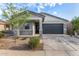 Charming single-story home with a two-car garage, stone accents, and desert landscaping at 39959 W Williams Way, Maricopa, AZ 85138