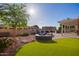 This backyard features artificial turf, desert landscaping, and a covered patio at 4055 N Recker Rd # 62, Mesa, AZ 85215