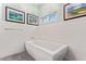 Bright bathroom featuring a modern soaking tub, textured tile walls, and decorative wall art at 4055 N Recker Rd # 62, Mesa, AZ 85215