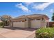 This attached three-car garage features automatic doors and is accented by lush trees and plants at 4055 N Recker Rd # 62, Mesa, AZ 85215