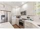 Modern kitchen featuring white cabinets, quartz countertops, stainless steel appliances, and stylish backsplash at 4055 N Recker Rd # 62, Mesa, AZ 85215