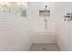 Modern shower featuring textured white tile, a built-in bench, and decorative tile accent at 4055 N Recker Rd # 62, Mesa, AZ 85215