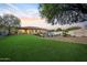 Expansive backyard with lush artificial turf, pool, and patio seating area at 4417 W El Cortez Trl, Phoenix, AZ 85083