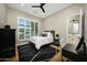 This bedroom features wood floors, a ceiling fan, and a large window with shutters at 4417 W El Cortez Trl, Phoenix, AZ 85083