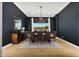 Dining room with large window, dark walls, hardwood floors, and modern chandelier at 4417 W El Cortez Trl, Phoenix, AZ 85083
