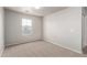 Neutral bedroom with carpeted floor, white walls, and a sunlit window at 45018 W Sage Brush Dr, Maricopa, AZ 85139