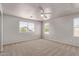 Sunlit bedroom with neutral walls, plush carpet, and bright windows at 45018 W Sage Brush Dr, Maricopa, AZ 85139
