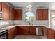 Close up on a kitchen featuring cherry wood cabinets, stainless steel dishwasher, and breakfast bar with seating at 45018 W Sage Brush Dr, Maricopa, AZ 85139