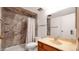 Bathroom with decorative stone-look shower surround and safety grab bars at 4630 N 68Th St # 265, Scottsdale, AZ 85251
