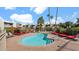 A community pool is surrounded by red lounge chairs and palm trees at 4630 N 68Th St # 265, Scottsdale, AZ 85251