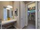 Elegant bathroom vanity with a mirror, modern lighting, and access to a well-organized walk-in closet at 4714 E Lewis Ave, Phoenix, AZ 85008