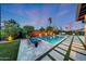 Stunning backyard pool featuring elegant pavers, artificial turf, and captivating fire features at 4714 E Lewis Ave, Phoenix, AZ 85008