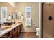 Bathroom features a dual vanity, neutral toned walls, framed mirrors, plantation shutters, and a shower at 5621 E Lonesome Trl, Cave Creek, AZ 85331