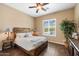 Comfortable bedroom with wood-style bed frame, plantation shutters on the window, and a ceiling fan at 5621 E Lonesome Trl, Cave Creek, AZ 85331
