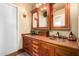 Bathroom featuring wooden cabinets with dual sinks and decorative mirrors and access to the shower at 6101 E Thunderbird Rd, Scottsdale, AZ 85254