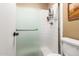 Bathroom featuring a shower with glass doors, tiled walls, and a white toilet at 6101 E Thunderbird Rd, Scottsdale, AZ 85254