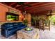 Comfortable covered patio with a sofa, rustic wooden table, ceiling fans, and decorative accents at 6101 E Thunderbird Rd, Scottsdale, AZ 85254