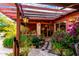 Welcoming landscaped entryway features stone walkway, covered pergola, hanging lantern and lush plantings at 6101 E Thunderbird Rd, Scottsdale, AZ 85254