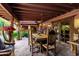 Inviting outdoor dining area on a covered patio with a rustic wooden table, chairs, and ambient lighting at 6101 E Thunderbird Rd, Scottsdale, AZ 85254