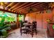 Charming covered patio features a rustic wooden table, exposed beams, and a lush green view at 6101 E Thunderbird Rd, Scottsdale, AZ 85254
