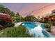 Lush backyard featuring a pool, dining area and an outdoor seating area covered with delicate string lights at 6101 E Thunderbird Rd, Scottsdale, AZ 85254
