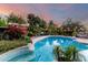 Backyard oasis with a sparkling pool surrounded by lush greenery and ambient lighting perfect for outdoor relaxation and enjoyment at 6101 E Thunderbird Rd, Scottsdale, AZ 85254