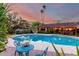 Charming backyard pool area featuring an outdoor dining set and ambient lighting creating a serene oasis for relaxation at 6101 E Thunderbird Rd, Scottsdale, AZ 85254