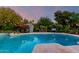 Stunning backyard pool area adorned with lush plants, a charming shed, and ambient string lights for evening enjoyment at 6101 E Thunderbird Rd, Scottsdale, AZ 85254