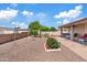 Expansive gravel backyard featuring a covered patio, desert landscaping and decorative features and a block fence at 6237 E Boston St, Mesa, AZ 85205